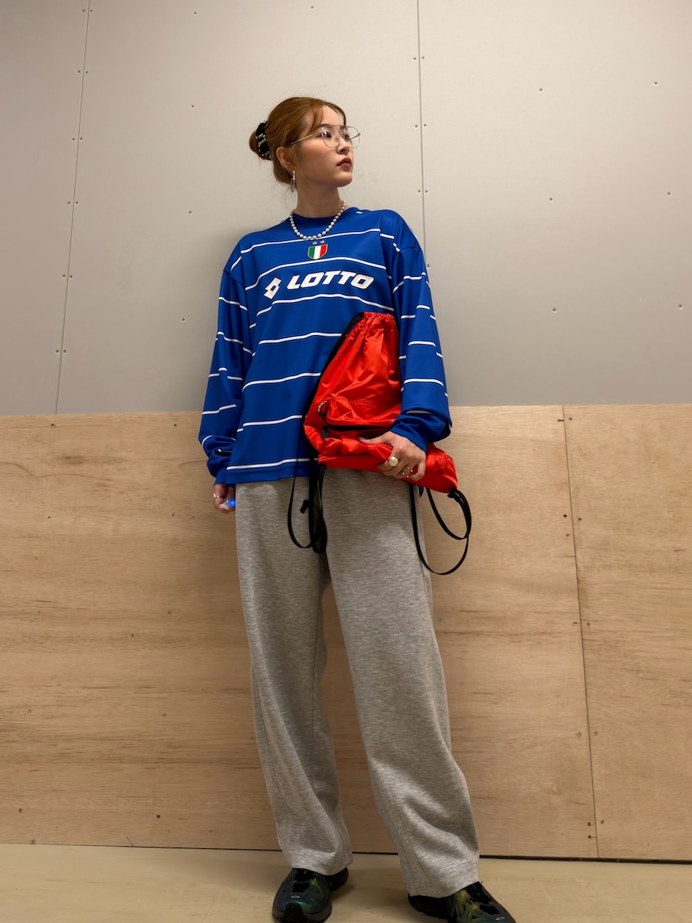 レッド系のバックパック/リュック、ブルー系のTシャツ/カットソー、グレー系のその他パンツを着用したレディースの冬コーディネートの3枚目の写真