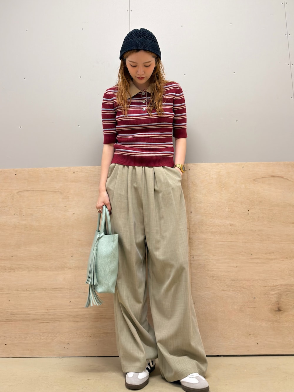 ベージュ系のその他パンツ、レッド系のニット/セーター、ホワイト系のスニーカーを着用したレディースの夏コーディネートの2枚目の写真