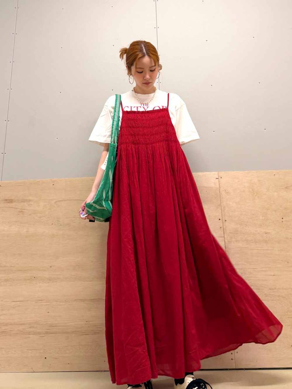 レッド系のワンピース、レッド系のTシャツ/カットソー、ベージュ系のスニーカーを着用したレディースの春コーディネートの2枚目の写真