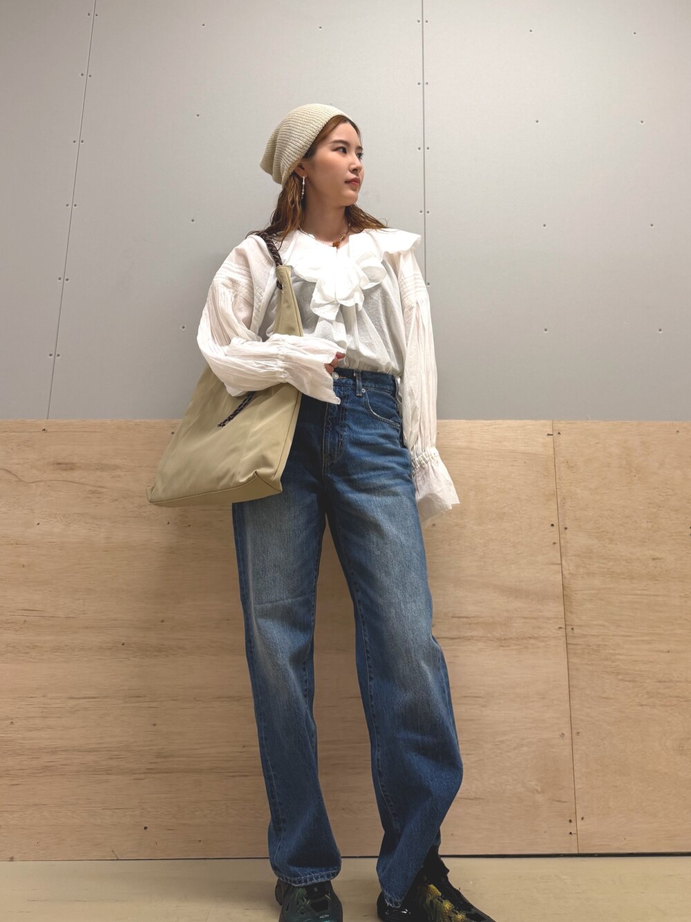 ベージュ系のトートバッグ、ブルー系のデニムパンツ、ホワイト系のシャツ/ブラウスを着用したレディースの春コーディネートの2枚目の写真