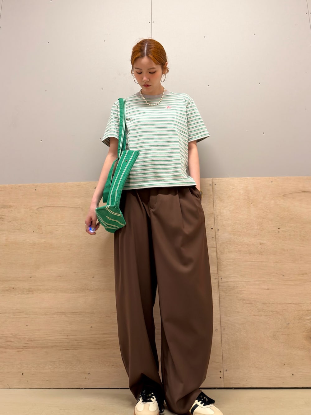 グリーン系のトートバッグ、ベージュ系のスニーカー、グリーン系のTシャツ/カットソーを着用したレディースの春コーディネートの2枚目の写真