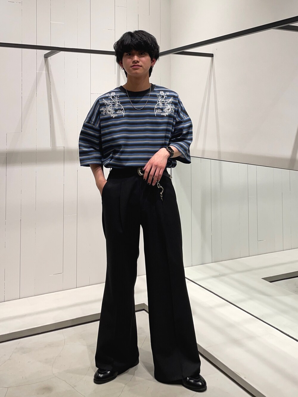 ブラック系のスラックス、ブラック系のドレスシューズ、ブルー系のTシャツ/カットソーを着用したメンズの春コーディネートの2枚目の写真