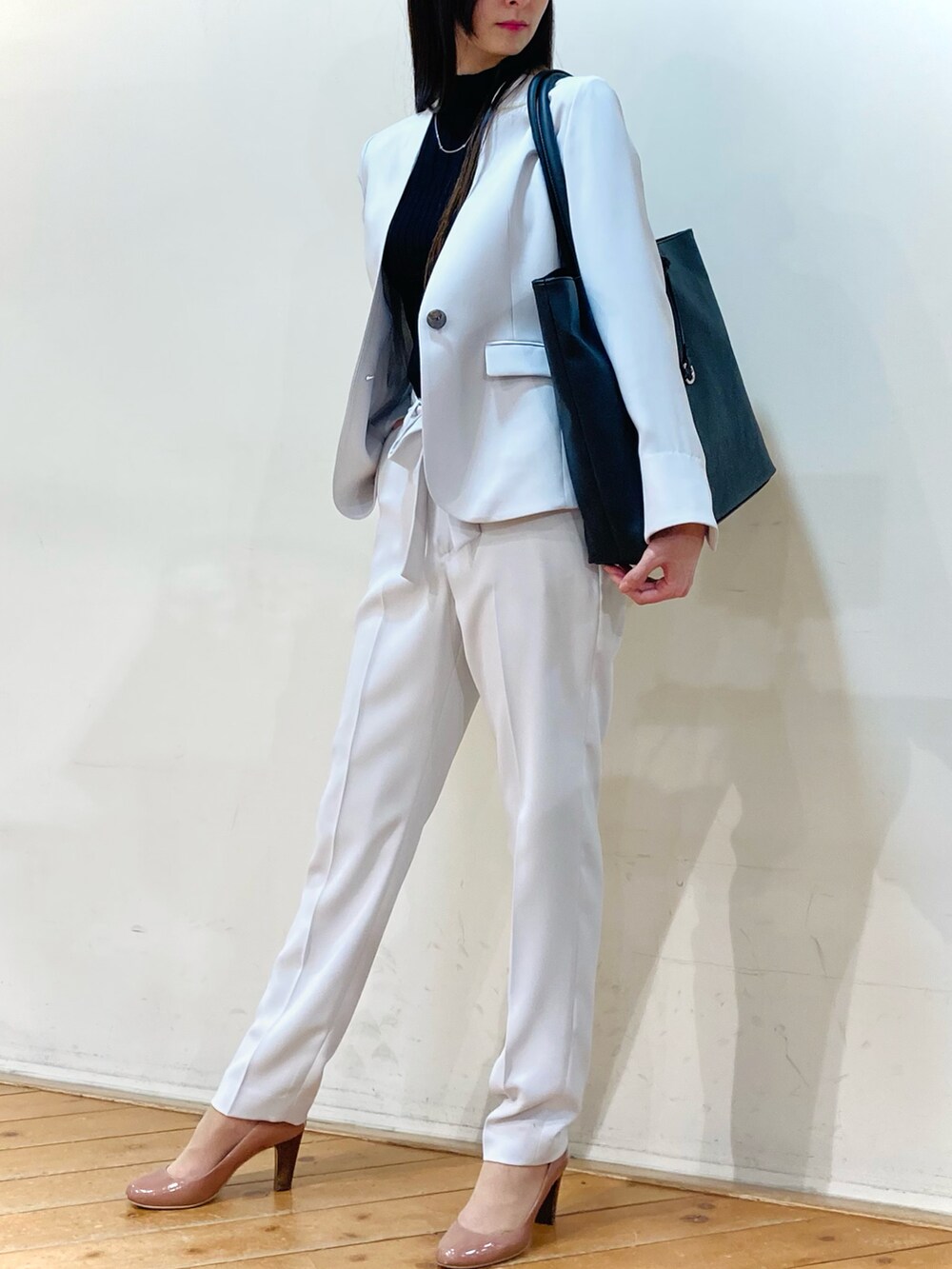 グレー系のスーツジャケット、グレー系のスーツパンツ、ブラック系のトートバッグを着用したレディースの春コーディネートの3枚目の写真