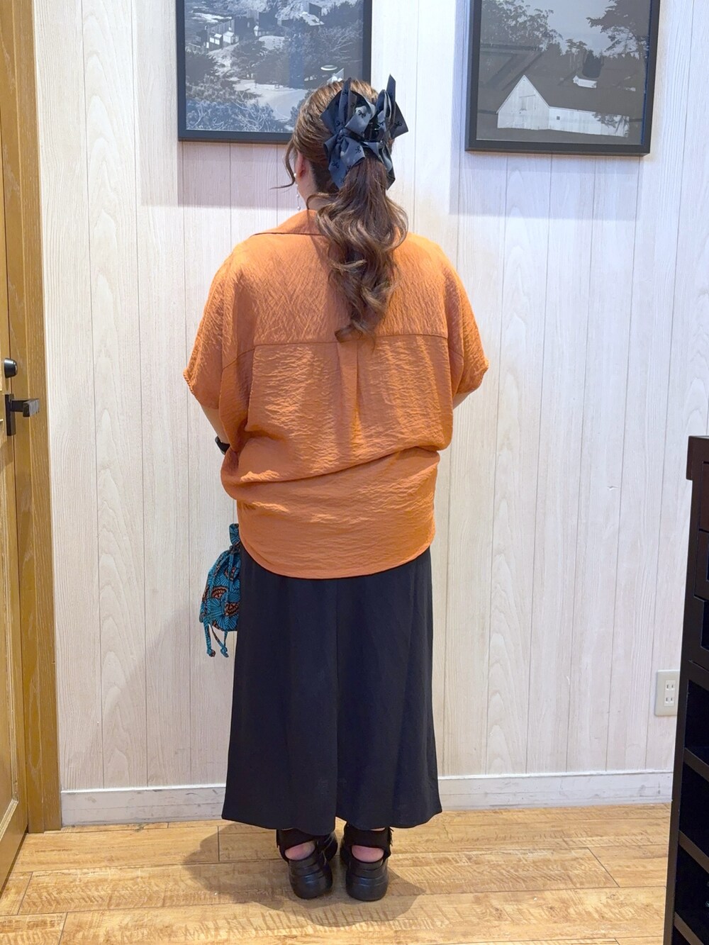 オレンジ系のシャツ/ブラウス、ブルー系のショルダーバッグ、ブルー系のスカートを着用したレディースの夏コーディネートの3枚目の写真