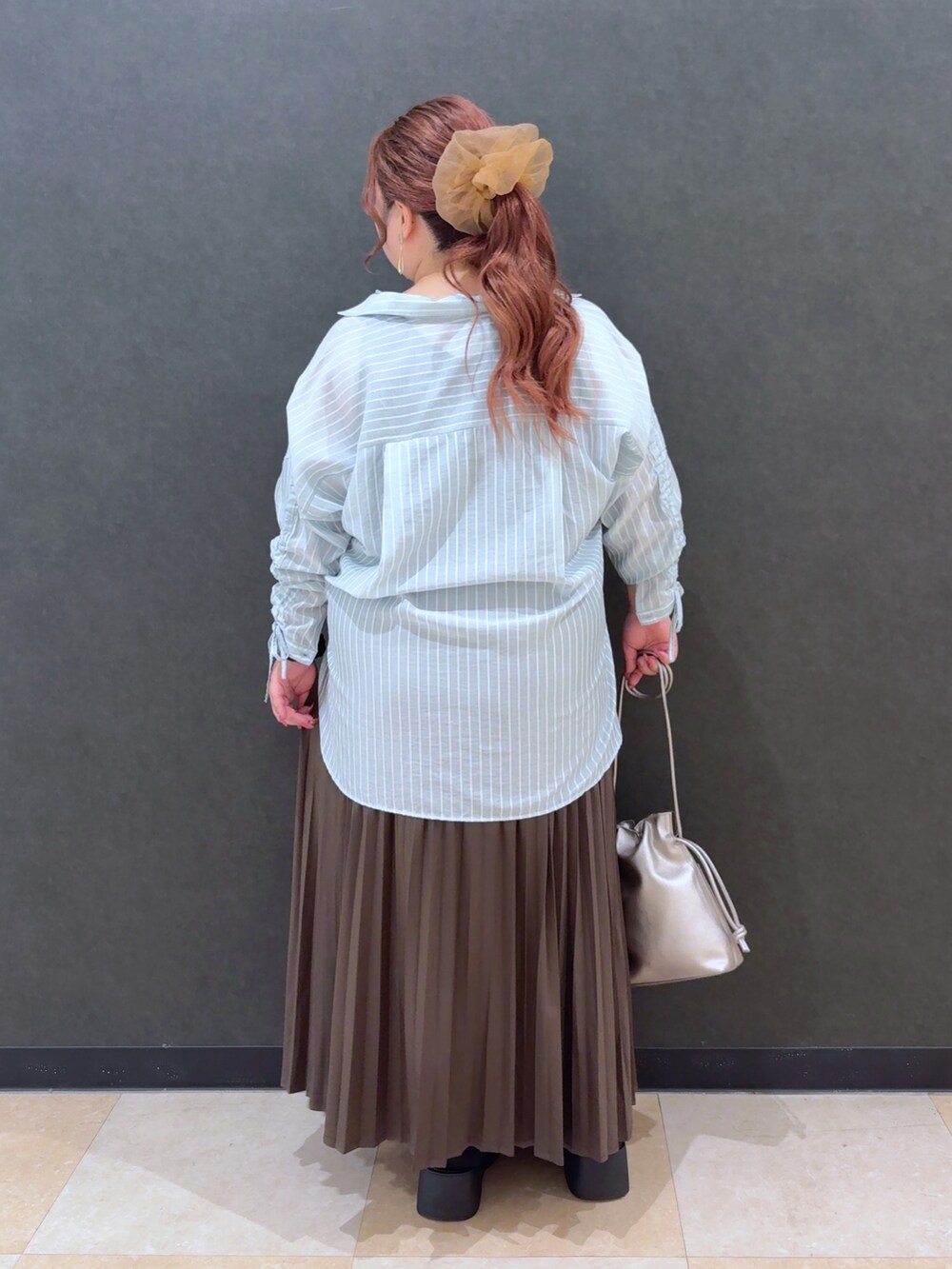 グリーン系のシャツ/ブラウス、ブラウン系のスカート、その他のショルダーバッグを着用したレディースの秋コーディネートの3枚目の写真