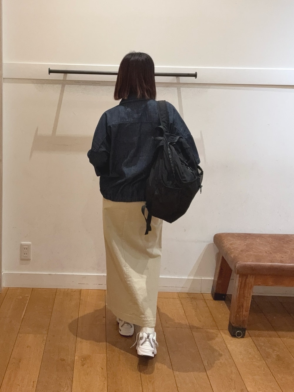 ブラック系のバックパック/リュック、ベージュ系のスカート、ブルー系のシャツ/ブラウスを着用したレディースの春コーディネートの2枚目の写真