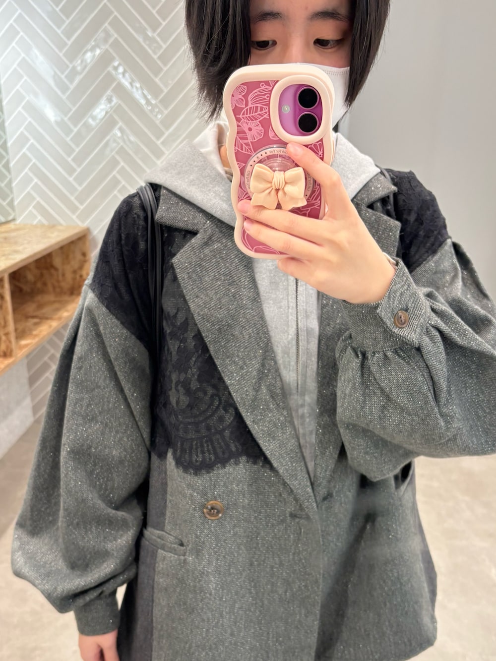 ピンク系のスニーカー、パープル系のデニムパンツ、グレー系のジャケット/アウターを着用したレディースの冬コーディネートの2枚目の写真