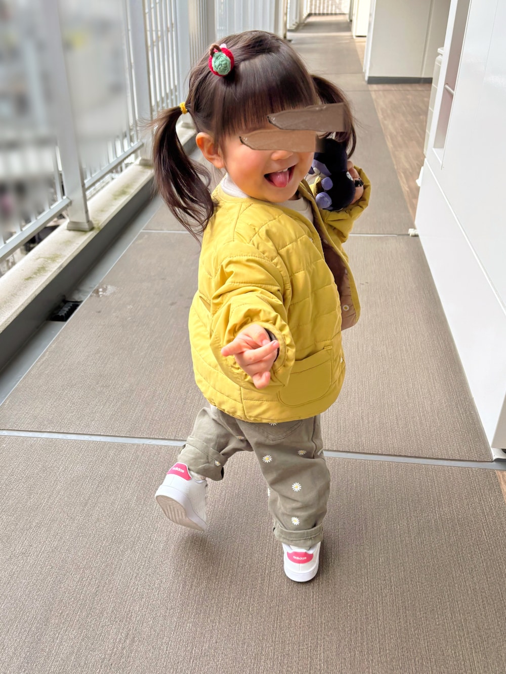 イエロー系のブルゾン、その他のオールインワン・サロペット、ホワイト系のスニーカーを着用したキッズの春コーディネートの4枚目の写真