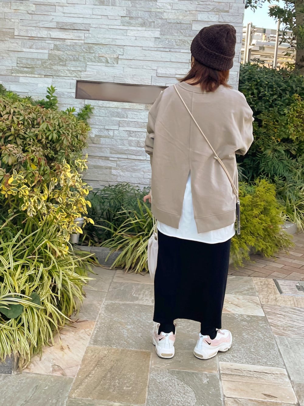 ブラウン系のその他トップス、ブラック系のスカート、ホワイト系のショルダーバッグを着用したレディースの冬コーディネートの3枚目の写真