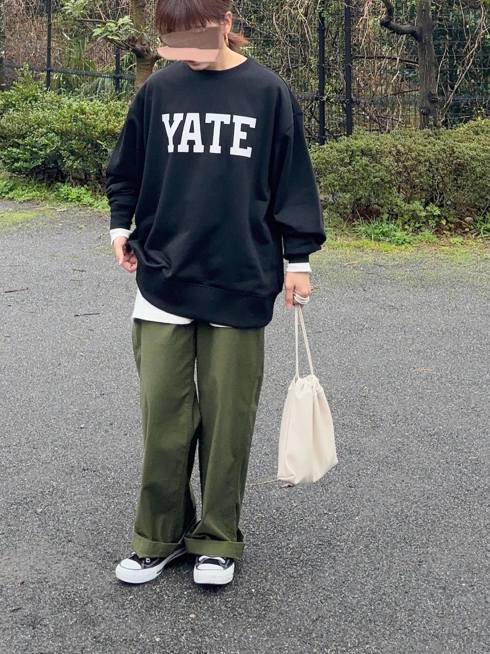 ブラック系のスウェット、ホワイト系のTシャツ/カットソー、グリーン系のカーゴパンツを着用したレディースの春コーディネートの3枚目の写真
