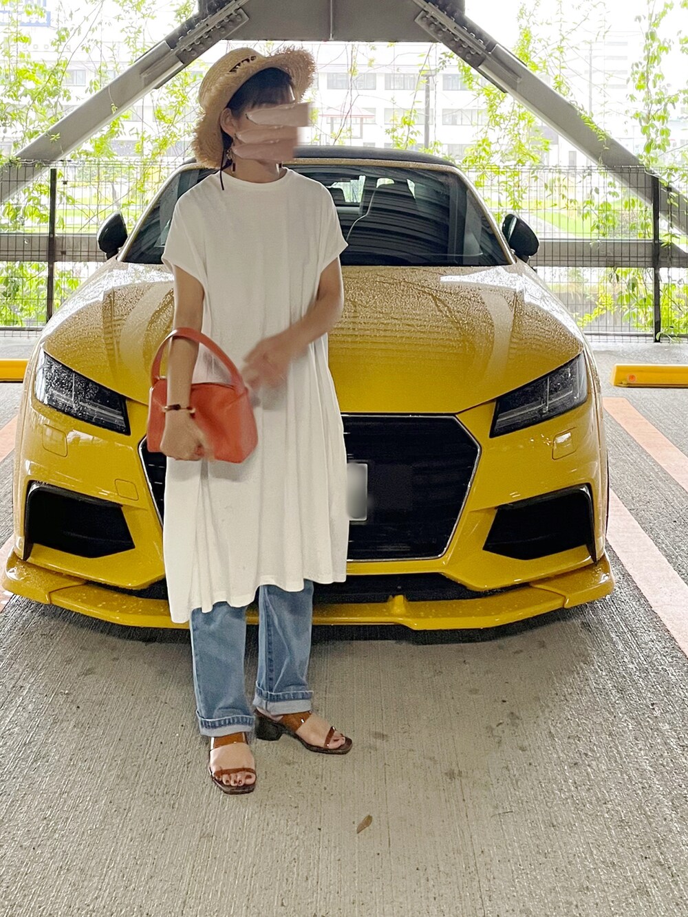 ホワイト系のワンピース、オレンジ系のハンドバッグ、ブルー系のデニムパンツを着用したレディースの夏コーディネートの3枚目の写真