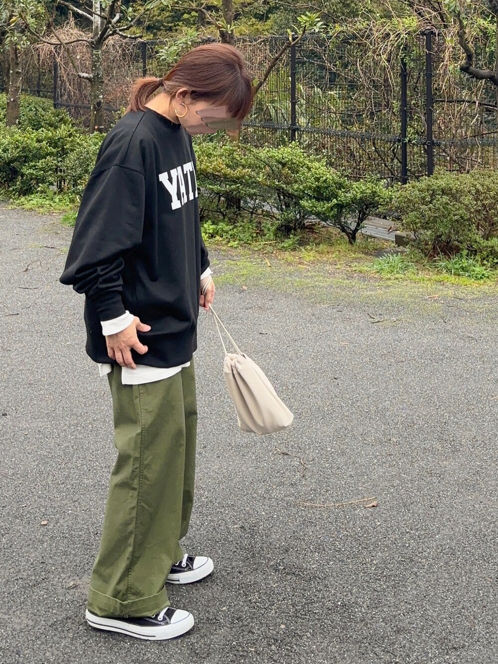 ブラック系のスウェット、ホワイト系のTシャツ/カットソー、グリーン系のカーゴパンツを着用したレディースの春コーディネートの2枚目の写真