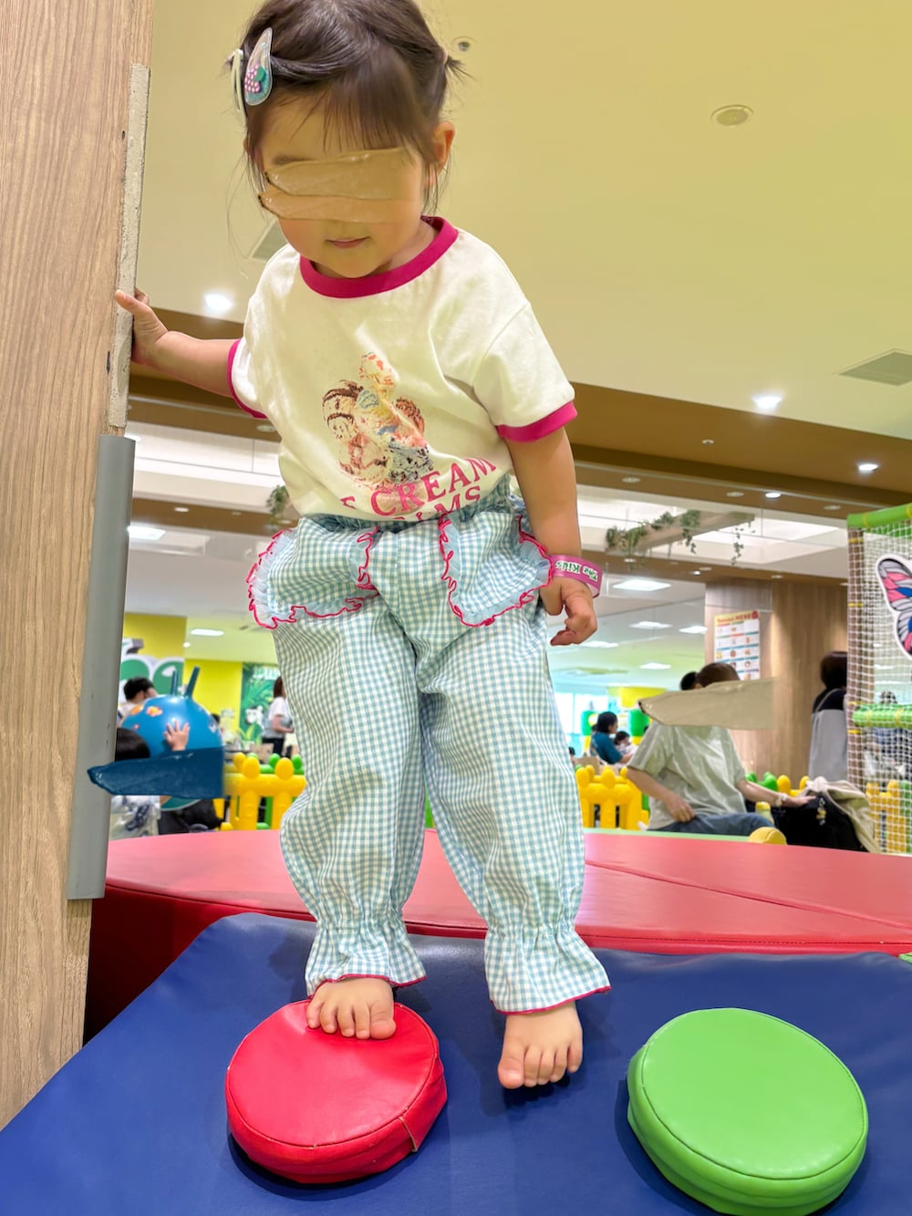 ピンク系のスニーカー、ブルー系のパンツを着用したキッズの秋コーディネートの2枚目の写真