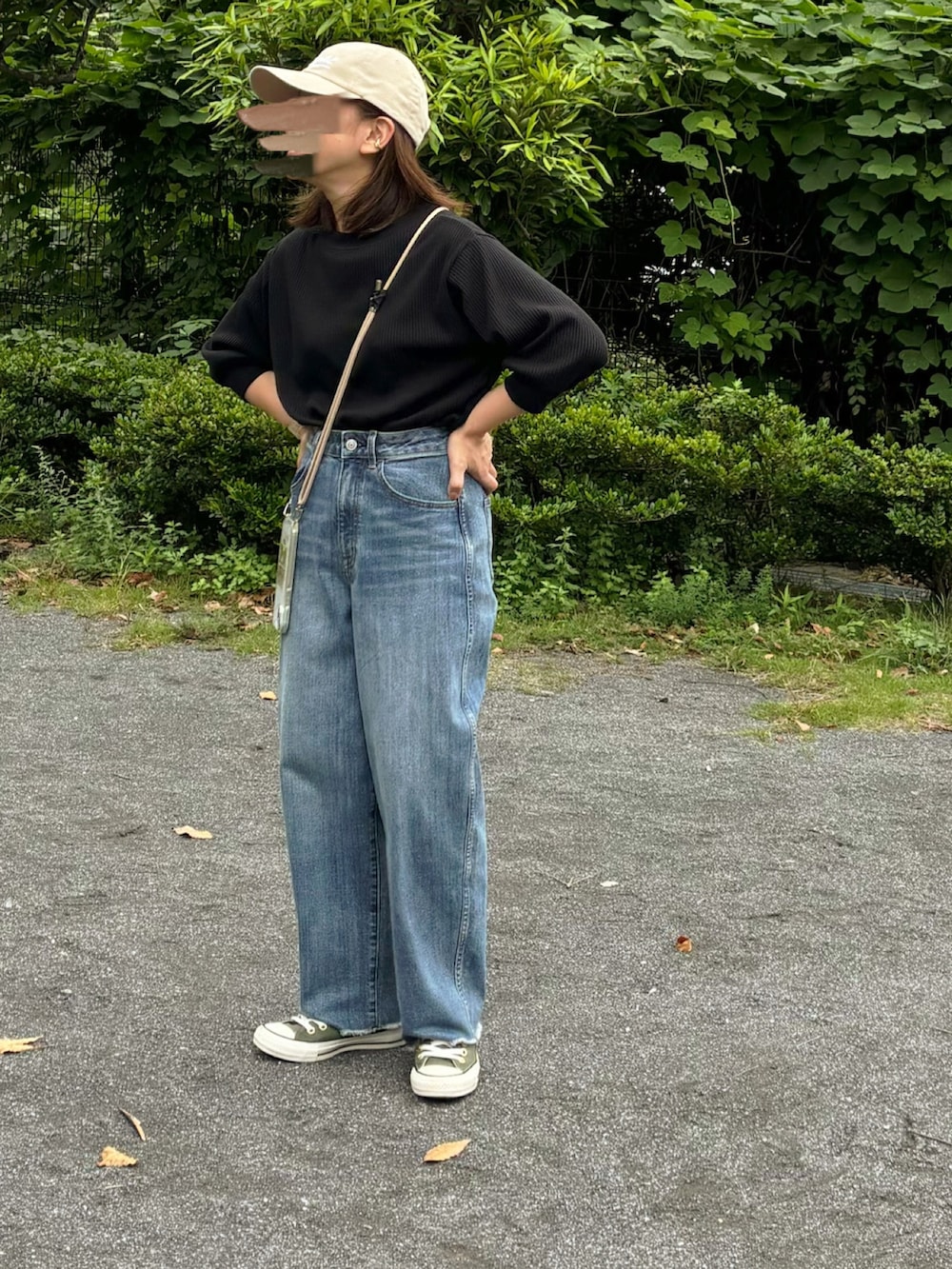 ブラック系のTシャツ/カットソー、ブルー系のデニムパンツ、グリーン系のスニーカーを着用したレディースの秋コーディネートの3枚目の写真