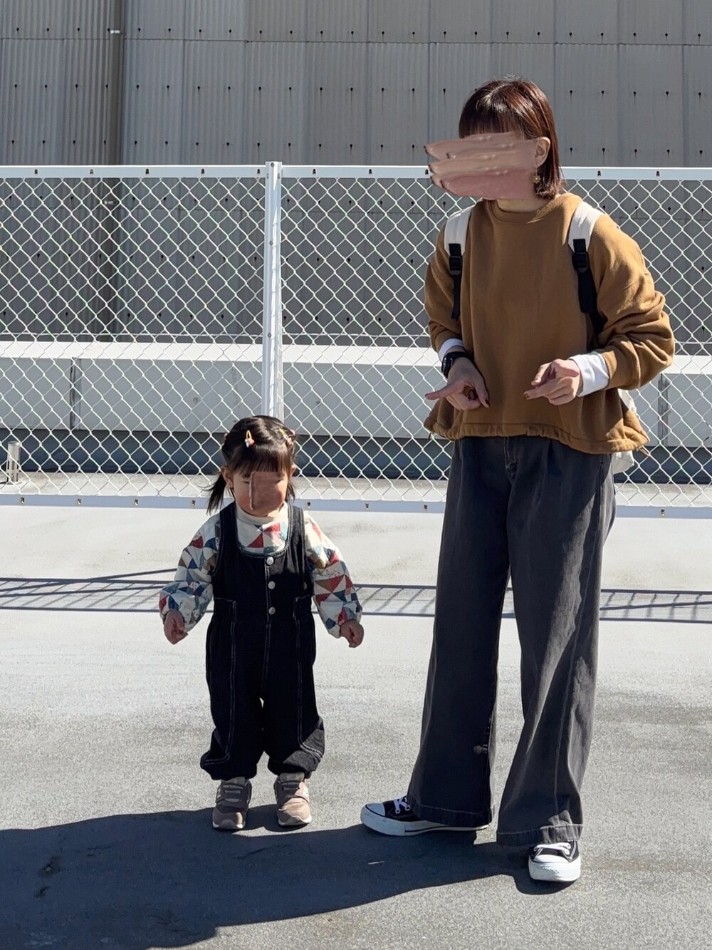 イエロー系のスウェット、ホワイト系のバックパック/リュック、ブラック系のパンツを着用したレディースの冬コーディネートの3枚目の写真