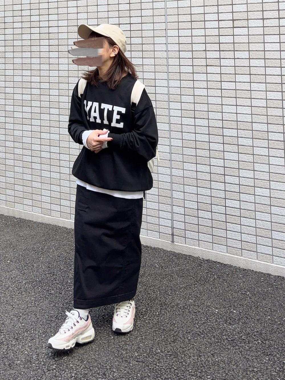 ブラック系のスウェット、ホワイト系のバックパック/リュック、ブラック系のスカートを着用したレディースの冬コーディネートの2枚目の写真