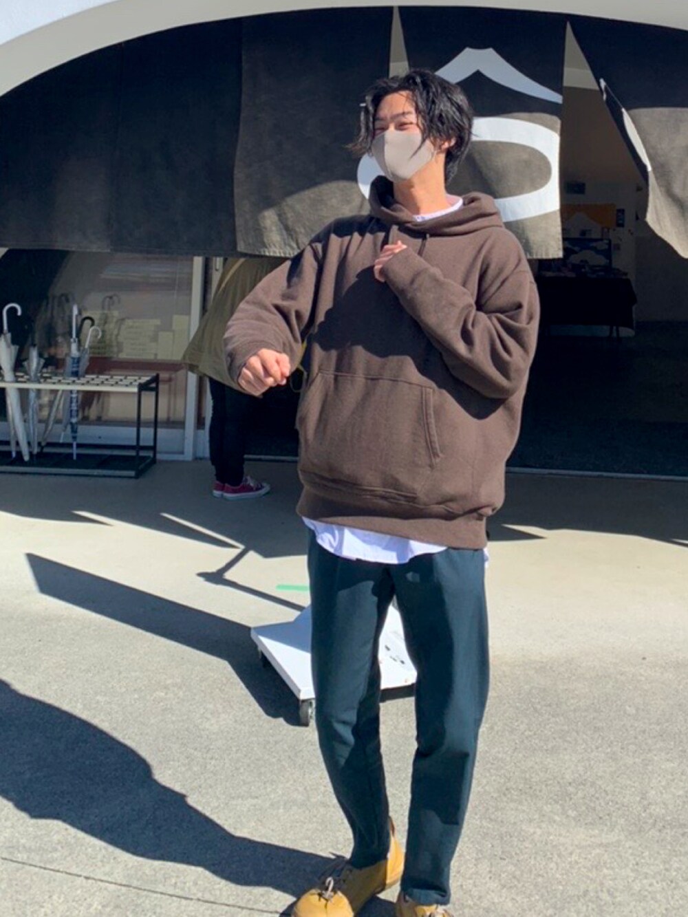 ブラウン系のパーカー、ホワイト系のシャツ/ブラウス、グリーン系のスラックスを着用したメンズの秋コーディネートの3枚目の写真