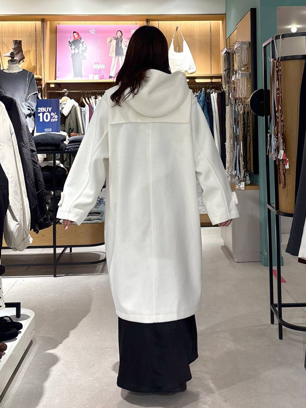 ブラック系のブーツ、ブラック系のスカート、ホワイト系のダッフルコートを着用したレディースの冬コーディネートの4枚目の写真