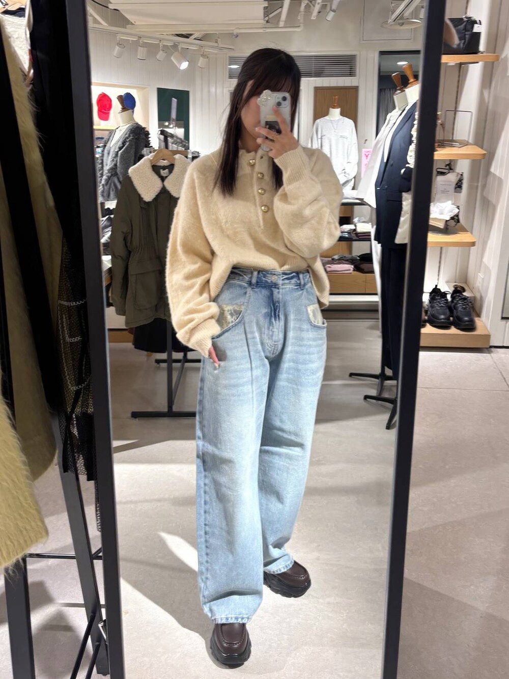 ホワイト系のニット/セーター、ブルー系のデニムパンツを着用したレディースの冬コーディネートの5枚目の写真