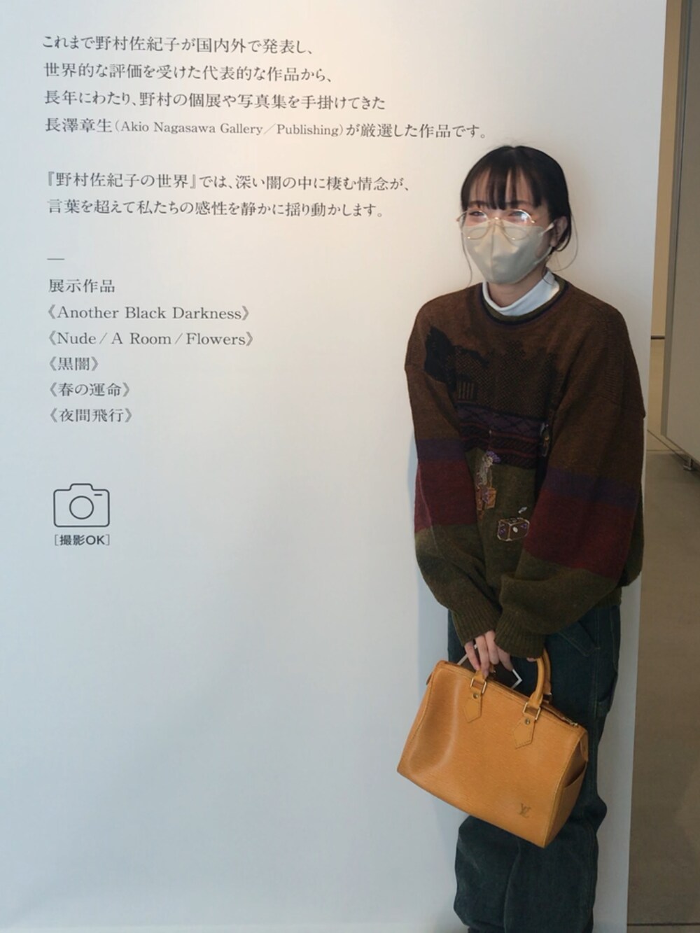 グリーン系のニット/セーター、ホワイト系のブーツ、オレンジ系のボストンバッグを着用したレディースの冬コーディネートの2枚目の写真