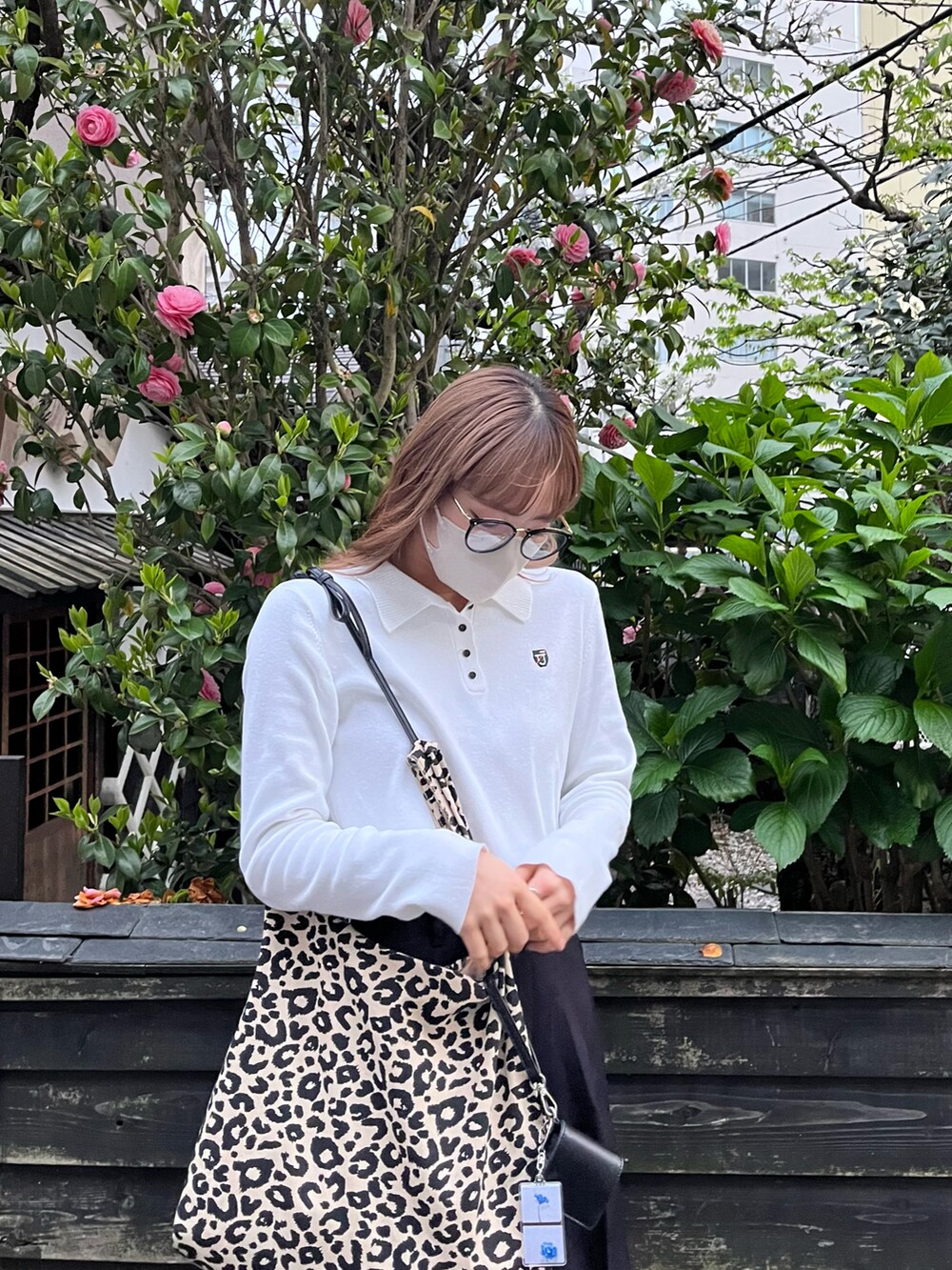 その他のトートバッグ、ホワイト系のポロシャツ、ブラック系のスラックスを着用したレディースの春コーディネートの3枚目の写真