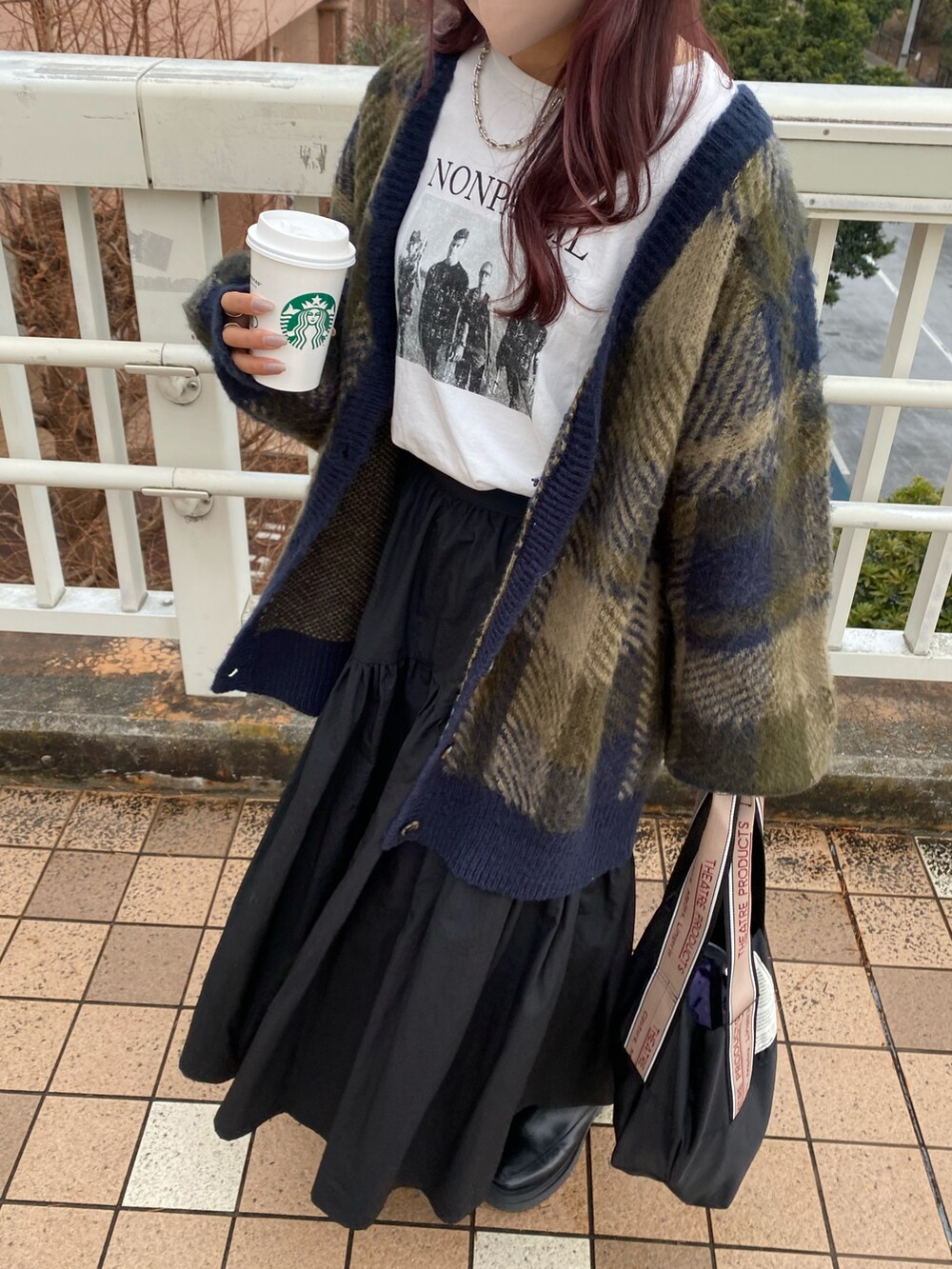 ブラック系のスカート、グリーン系のカーディガン/ボレロ、ホワイト系のTシャツ/カットソーを着用したレディースの冬コーディネートの2枚目の写真