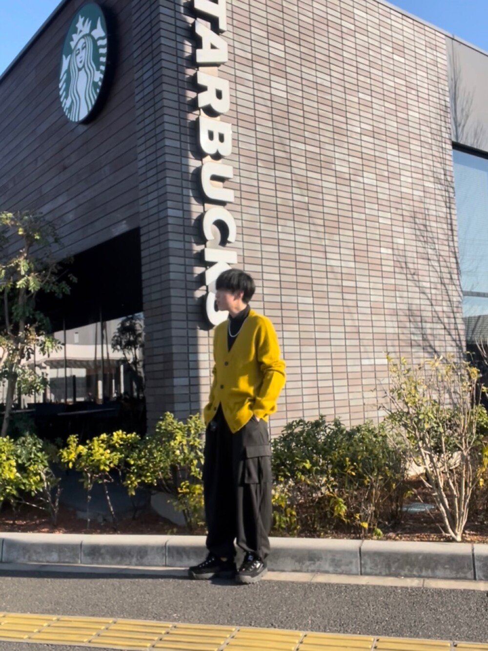 イエロー系のカーディガン/ボレロ、ブラック系のカーゴパンツ、ブラック系のスニーカーを着用したメンズの冬コーディネートの2枚目の写真