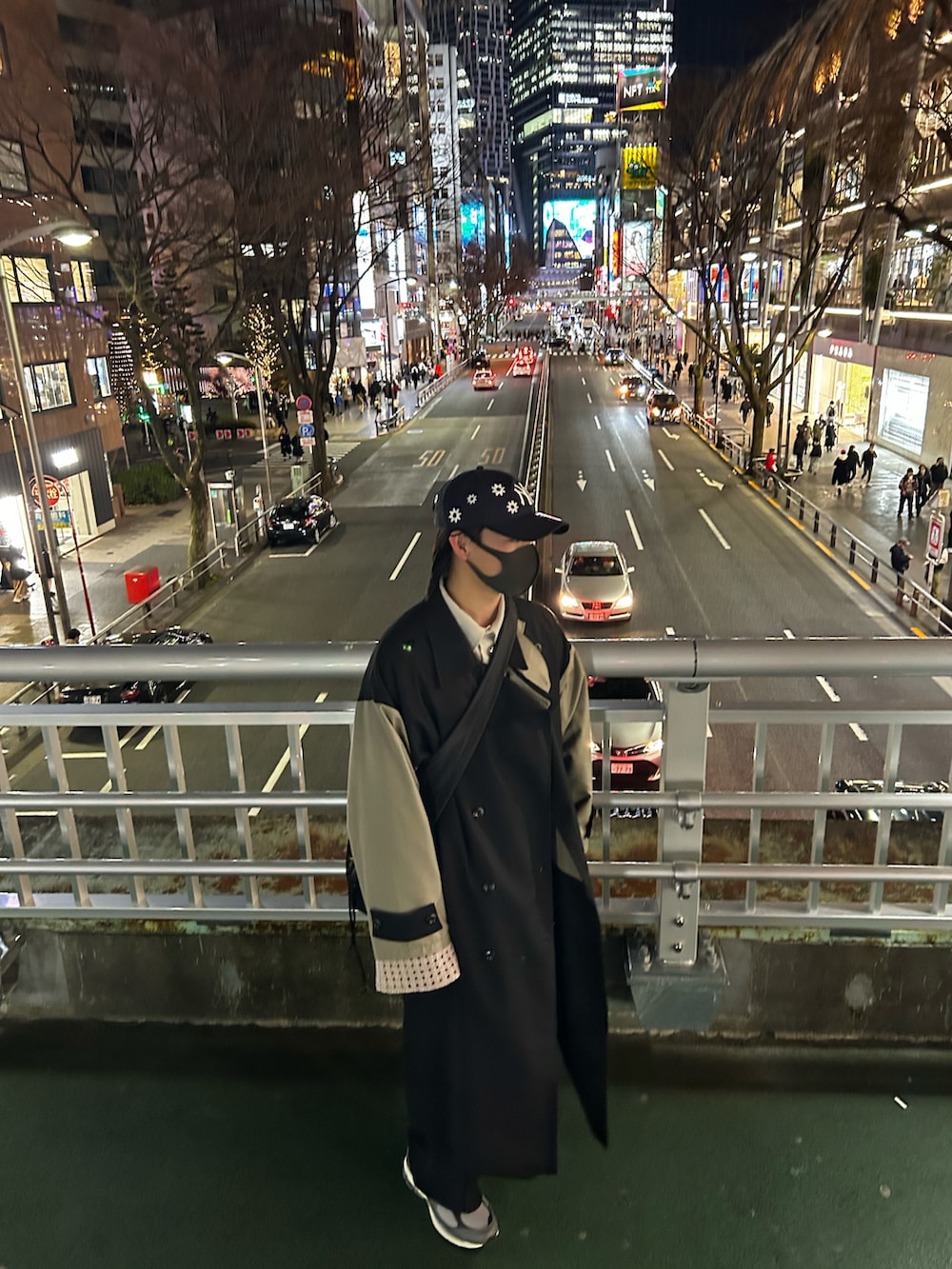 グレー系のスニーカー、ベージュ系のカーディガン/ボレロ、ブラック系のトレンチコートを着用したメンズの春コーディネートの2枚目の写真