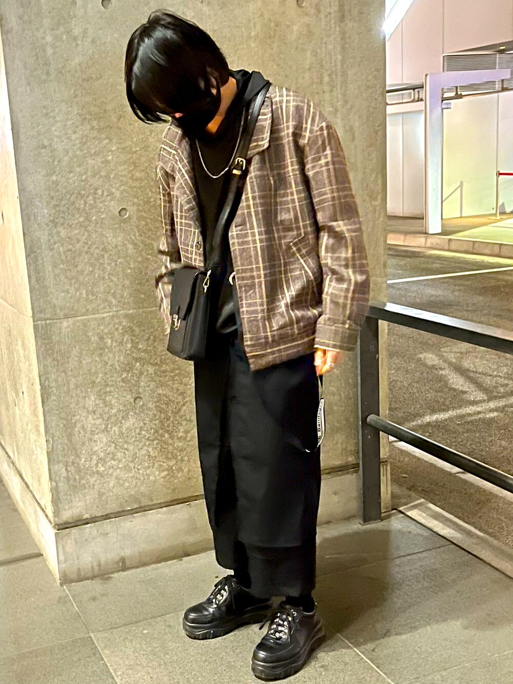 ブラック系のスニーカー、ブラック系のショルダーバッグ、シルバー系のネックレスを着用したメンズの春コーディネートの2枚目の写真