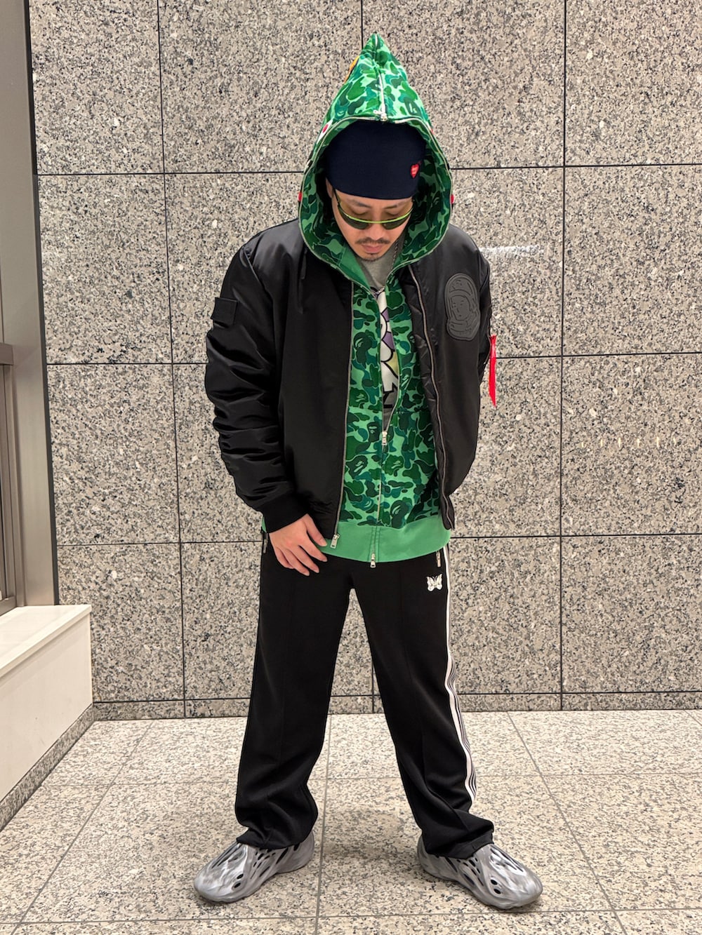 ブラック系のその他パンツ、グレー系のサンダル、グリーン系のパーカーを着用したメンズの冬コーディネートの2枚目の写真