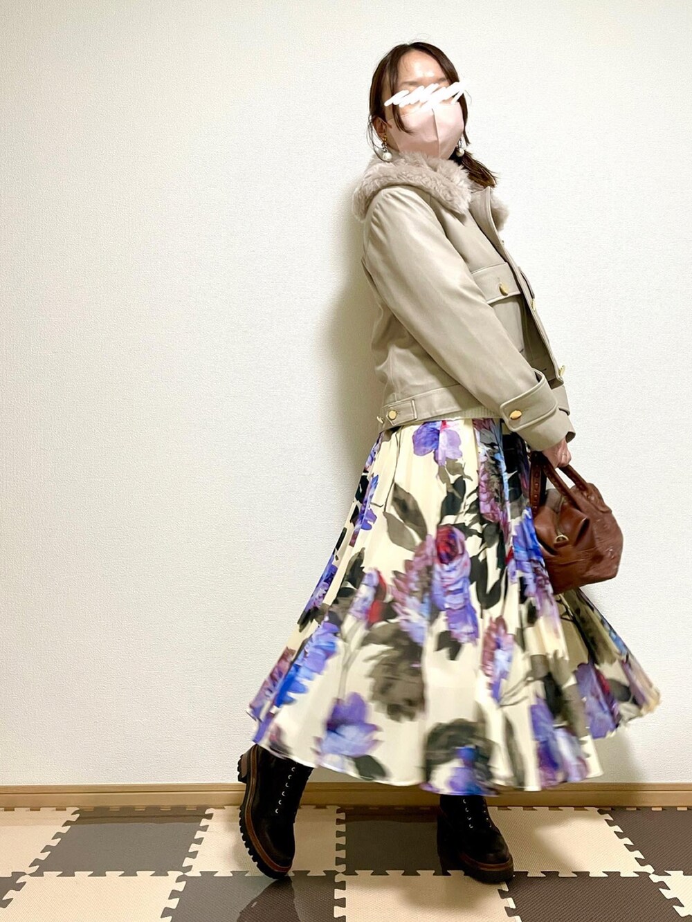 グレー系のダウンジャケット/コート、ホワイト系のニット/セーター、ブラウン系のボストンバッグを着用したレディースの秋コーディネートの3枚目の写真