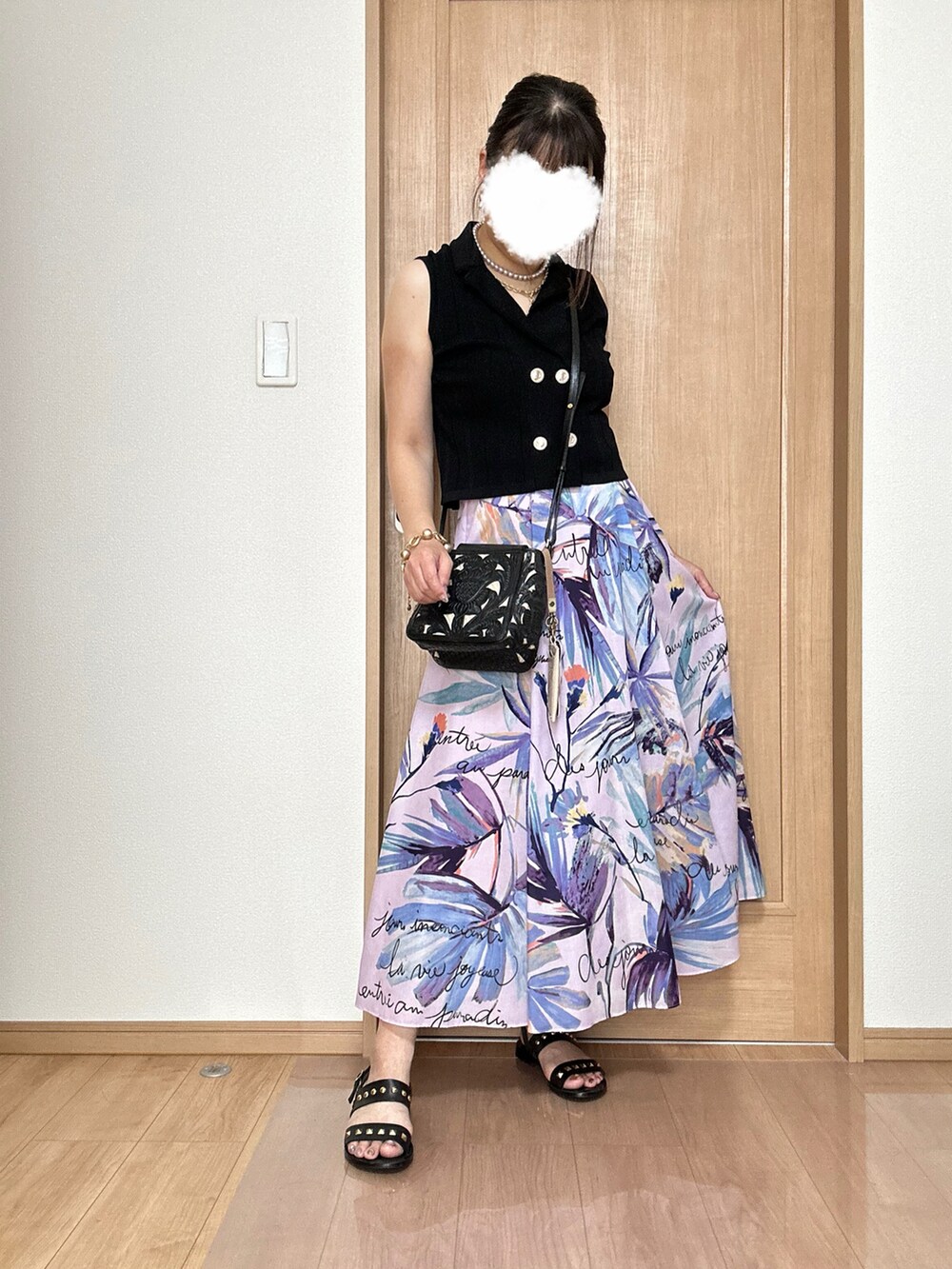 ブラック系のベスト、パープル系のスカート、ブラック系のショルダーバッグを着用したレディースの夏コーディネートの5枚目の写真