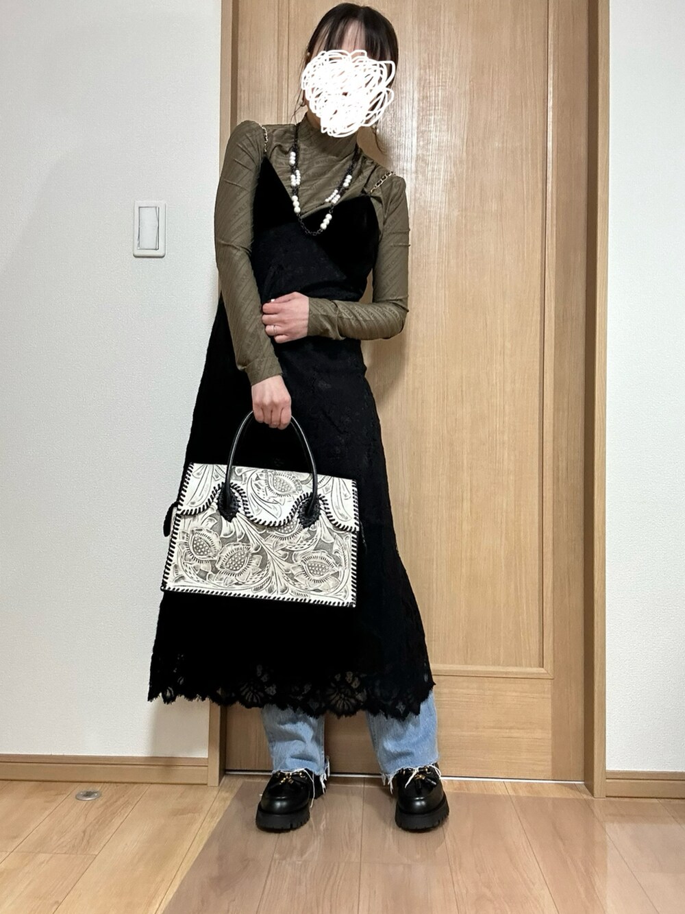 ブラック系のワンピース、ブラウン系のTシャツ/カットソー、ブラック系のバッグを着用したレディースの冬コーディネートの2枚目の写真