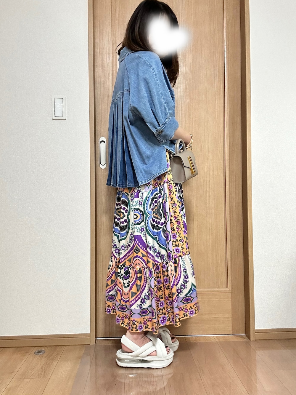 イエロー系のハンドバッグ、オレンジ系のワンピース、ブルー系のシャツ/ブラウスを着用したレディースの春コーディネートの3枚目の写真