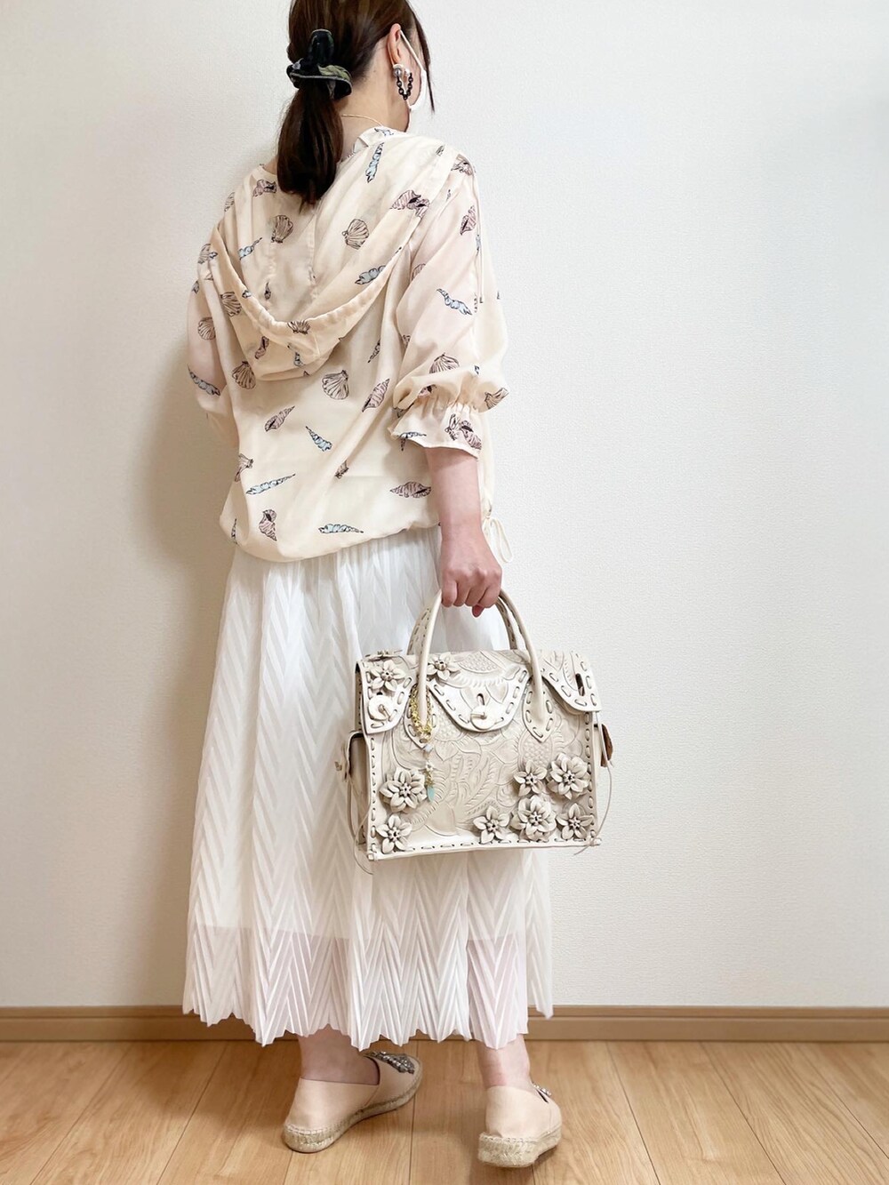 ホワイト系のスカート、ベージュ系のスリッポン、ホワイト系のハンドバッグを着用したレディースの春コーディネートの3枚目の写真