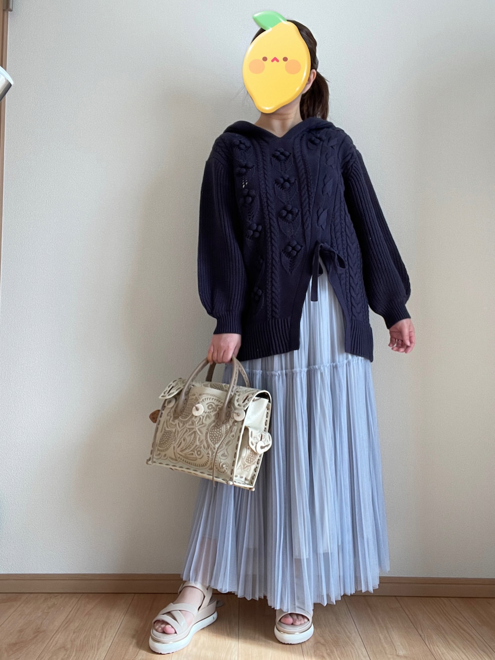 ブラウン系のハンドバッグ、ブルー系のスカート、ブルー系のニット/セーターを着用したレディースの冬コーディネートの2枚目の写真
