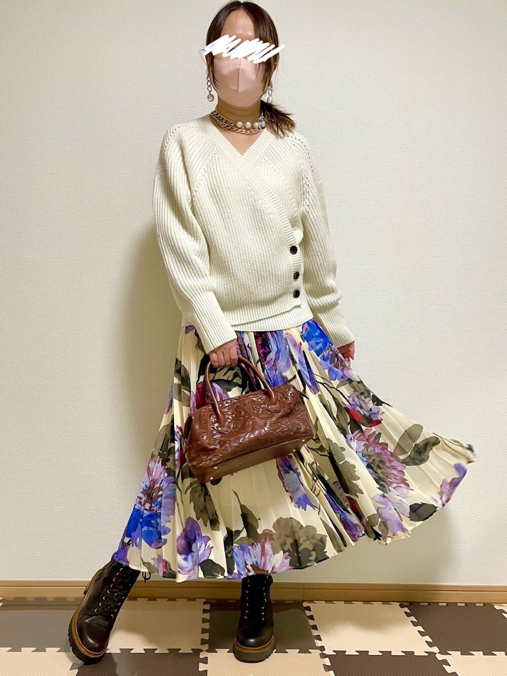 グレー系のダウンジャケット/コート、ホワイト系のニット/セーター、ブラウン系のボストンバッグを着用したレディースの秋コーディネートの4枚目の写真