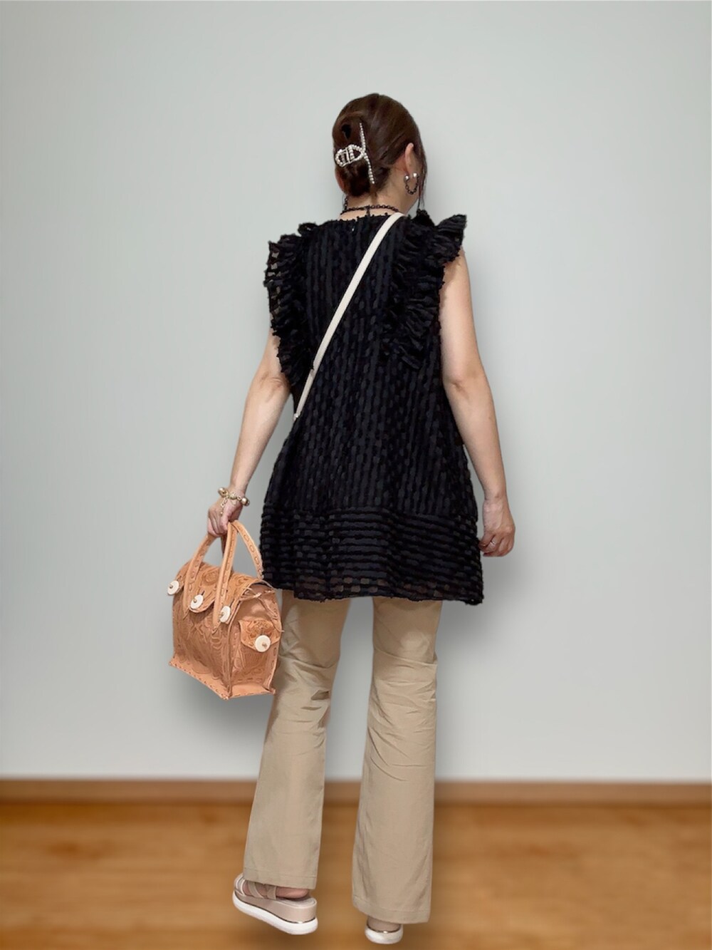 ベージュ系のハンドバッグ、ブラック系のトップス、ベージュ系のその他パンツを着用したレディースの秋コーディネートの3枚目の写真