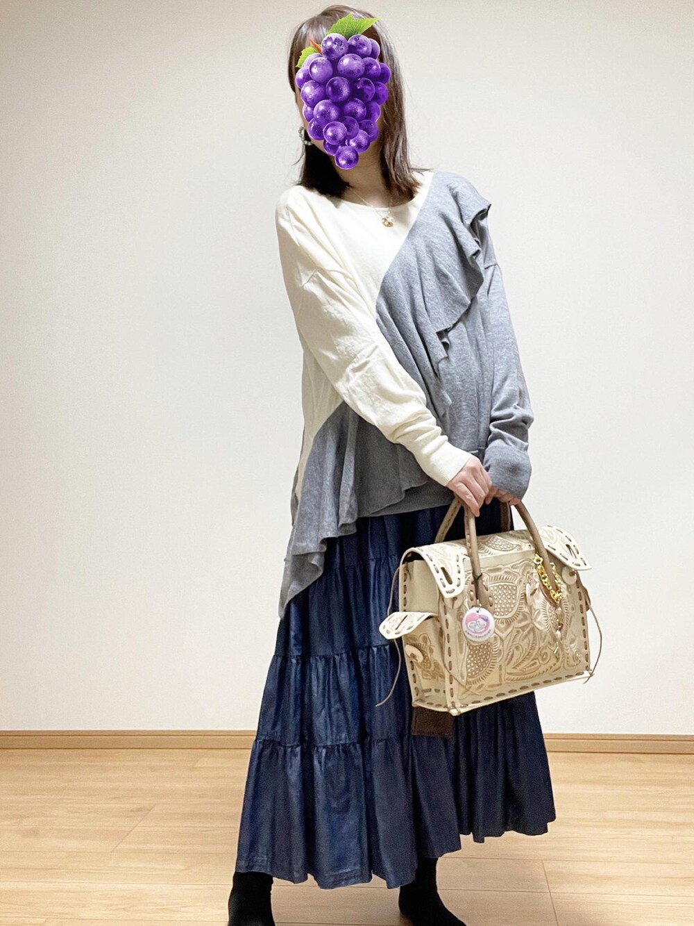 ブラウン系のハンドバッグ、ブルー系のスカート、グレー系のニット/セーターを着用したレディースの秋コーディネートの2枚目の写真