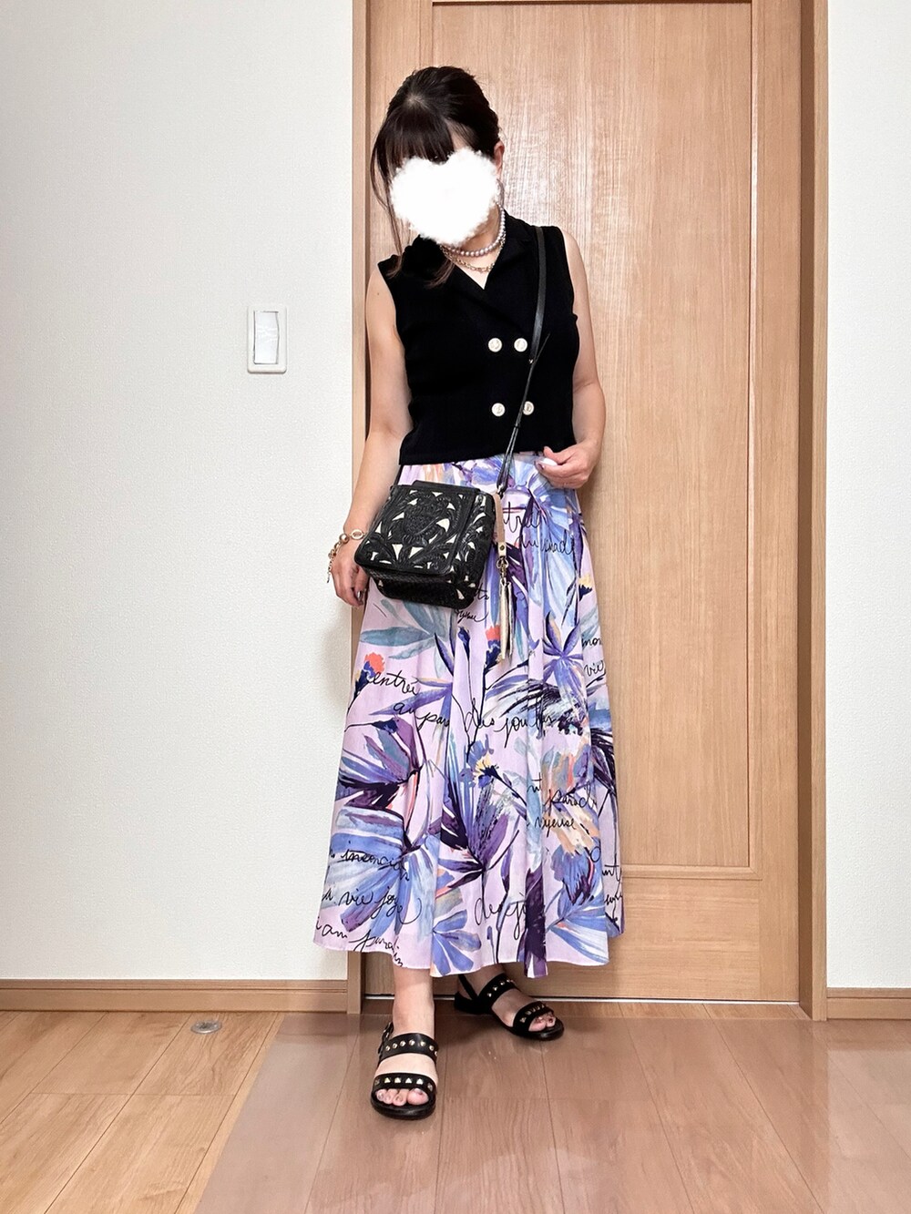 ブラック系のベスト、パープル系のスカート、ブラック系のショルダーバッグを着用したレディースの夏コーディネートの3枚目の写真