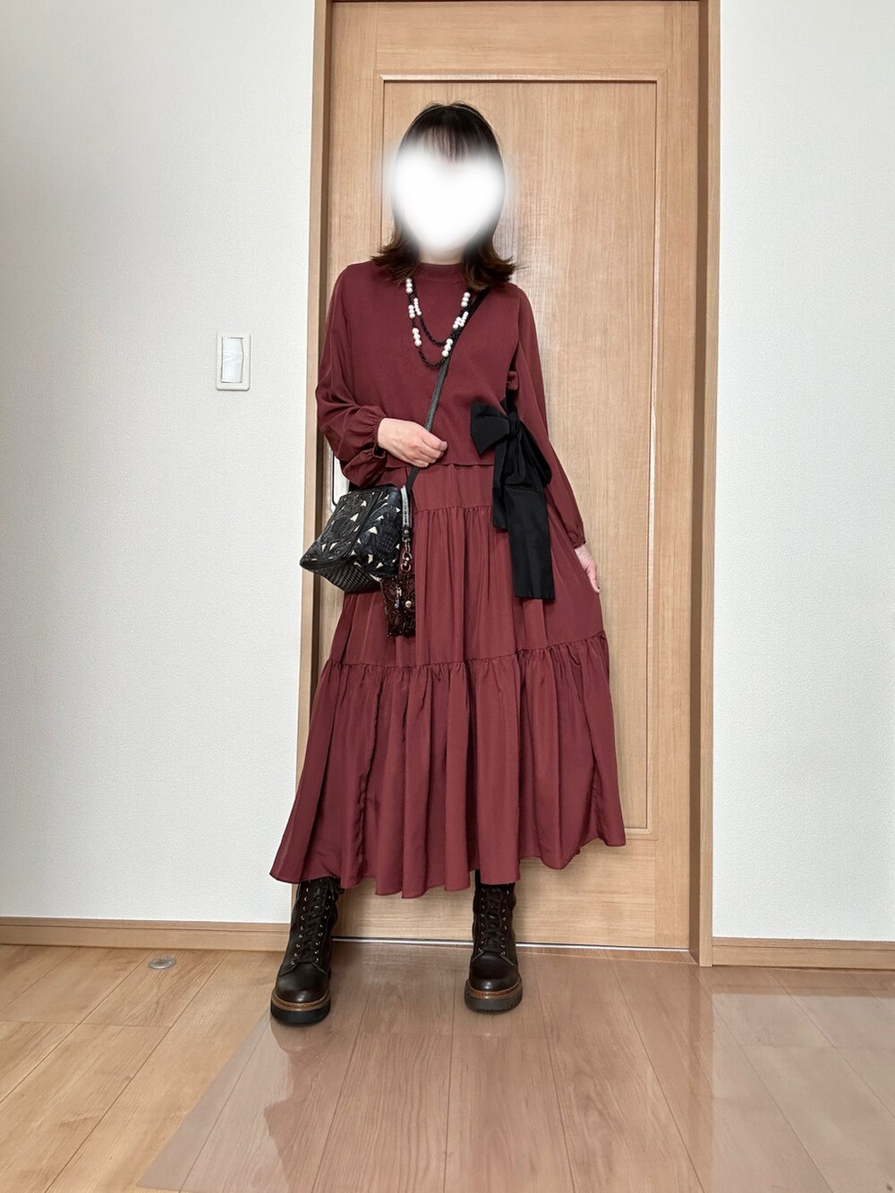 レッド系のワンピース/ドレス、ブラック系のショルダーバッグ、ブラウン系のブーツを着用したレディースの春コーディネートの2枚目の写真