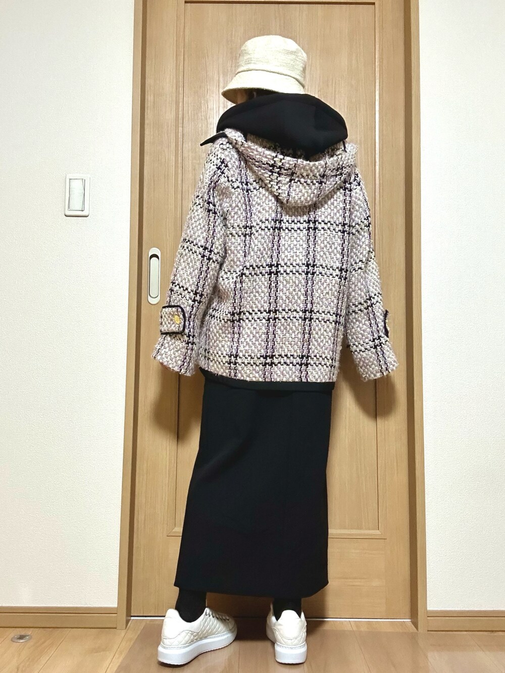 ホワイト系のバッグ、ブラック系のパーカー、ブラック系のスカートを着用したレディースの春コーディネートの5枚目の写真