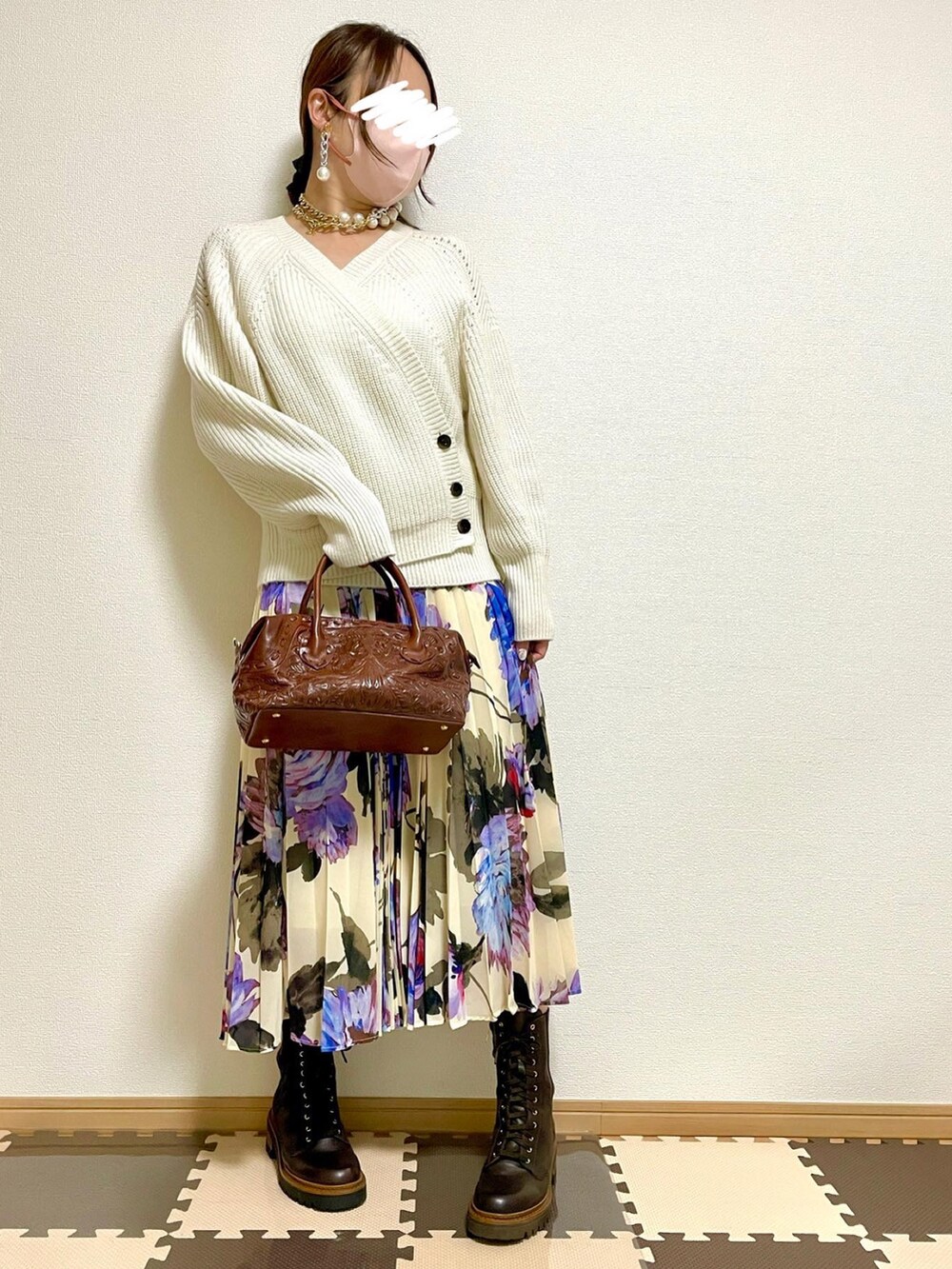 グレー系のダウンジャケット/コート、ホワイト系のニット/セーター、ブラウン系のボストンバッグを着用したレディースの秋コーディネートの5枚目の写真