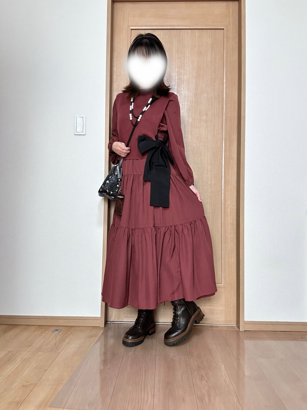 レッド系のワンピース/ドレス、ブラック系のショルダーバッグ、ブラウン系のブーツを着用したレディースの春コーディネートの3枚目の写真