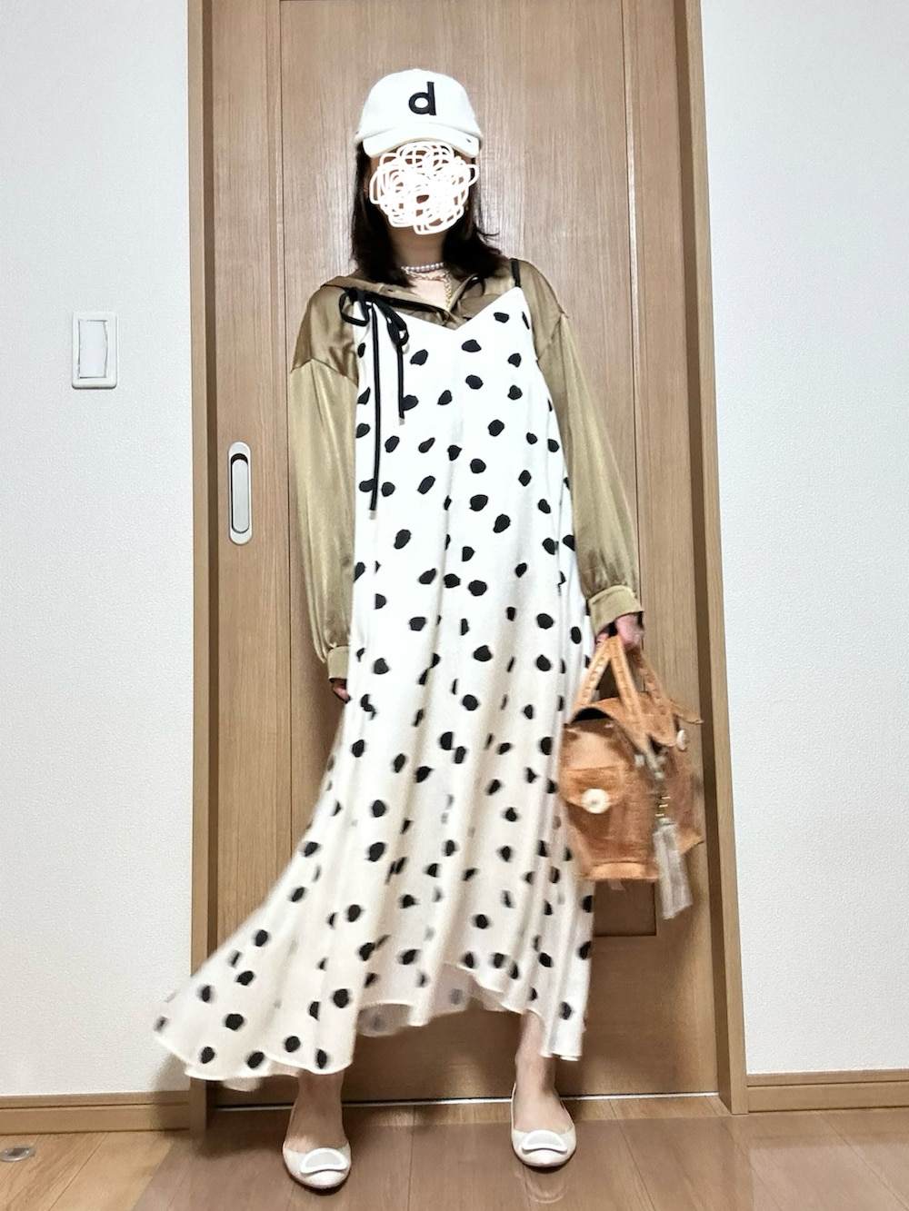 ホワイト系のワンピース、ベージュ系のハンドバッグ、ベージュ系のパンプスを着用したレディースの春コーディネートの2枚目の写真