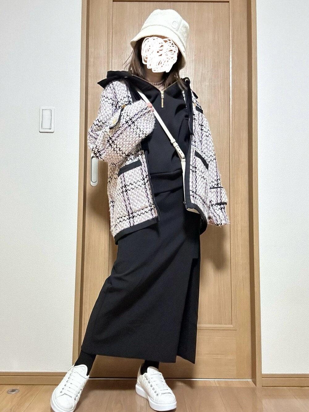 ホワイト系のバッグ、ブラック系のパーカー、ブラック系のスカートを着用したレディースの春コーディネートの4枚目の写真