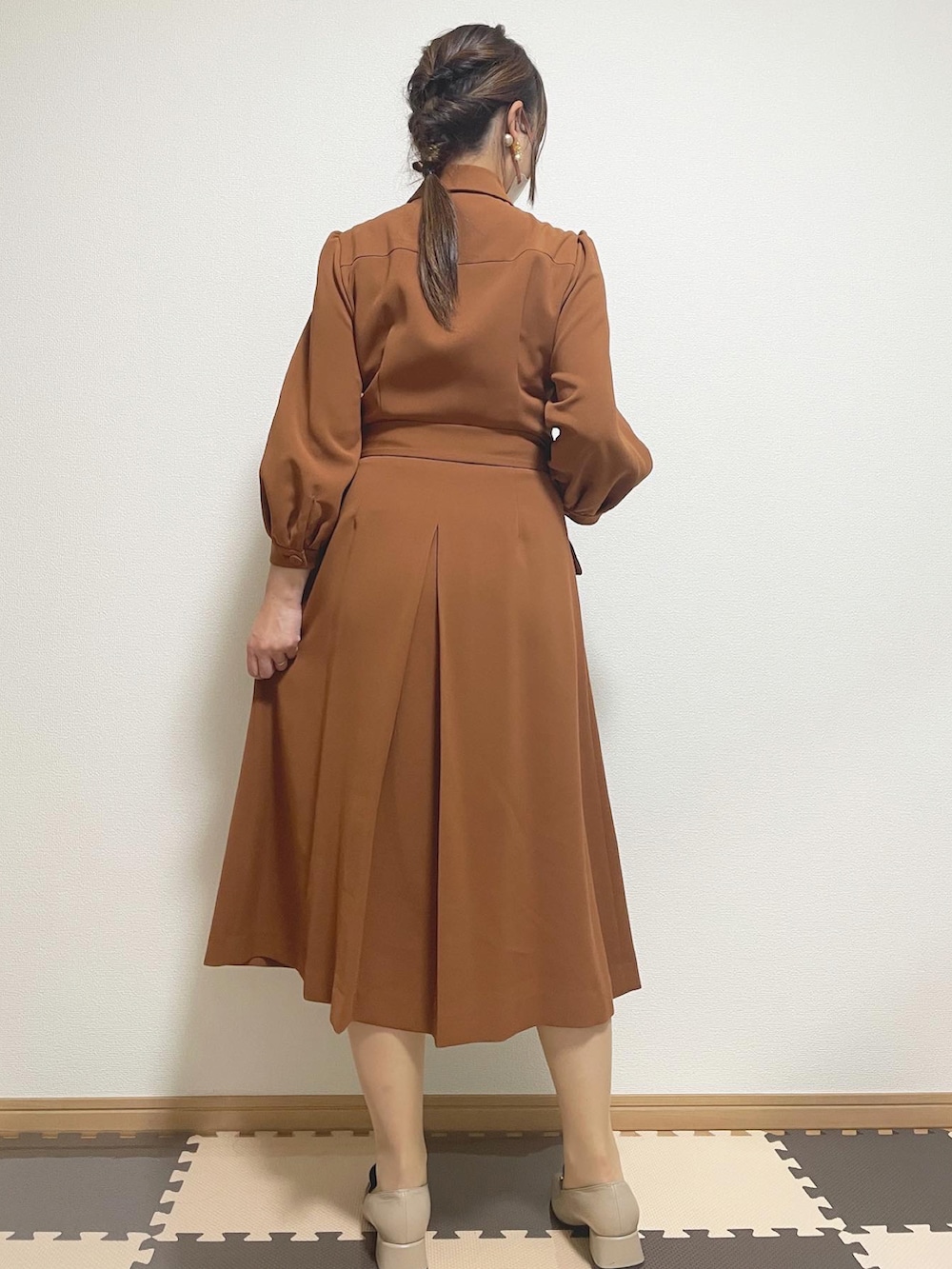 ブラック系のテーラードジャケット、ベージュ系のショルダーバッグ、ブラウン系のワンピースを着用したレディースの冬コーディネートの3枚目の写真