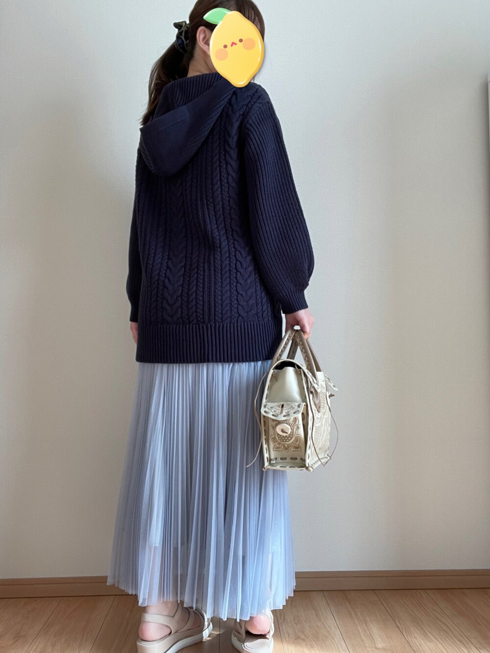 ブラウン系のハンドバッグ、ブルー系のスカート、ブルー系のニット/セーターを着用したレディースの冬コーディネートの3枚目の写真