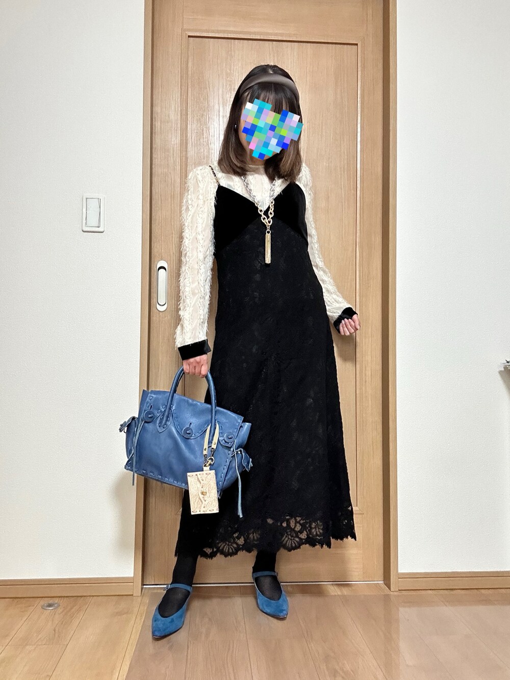 ブルー系のパンプス、ブラック系のワンピース、ブルー系のハンドバッグを着用したレディースの春コーディネートの2枚目の写真