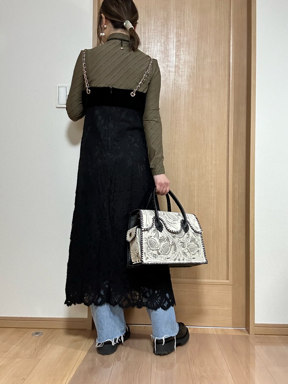 ブラック系のワンピース、ブラウン系のTシャツ/カットソー、ブラック系のバッグを着用したレディースの冬コーディネートの4枚目の写真